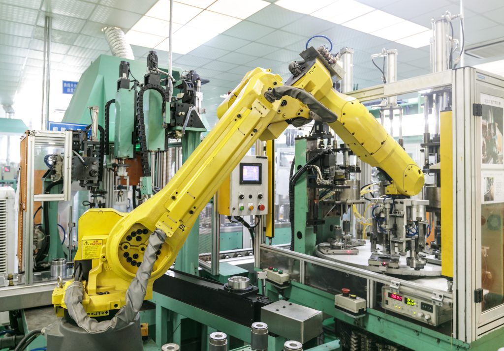 Robotic arm automating manufacturing processes in a factory, enhanced with custom manufacturing software solutions