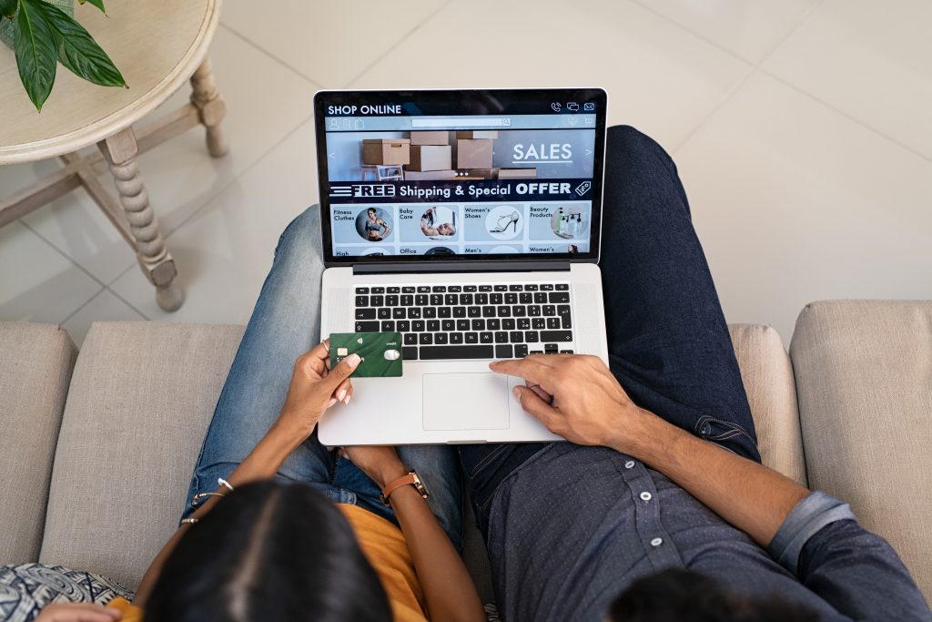 Executive using laptop for online shopping, demonstrating modern e-commerce software interface with sales dashboard and product catalog