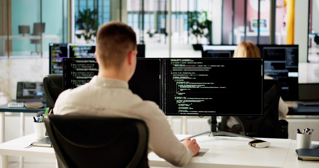 Multishoring Boomi consultant working on Dell Boomi integration platform at dual-monitor setup, focusing on Boomi integration services and solutions.