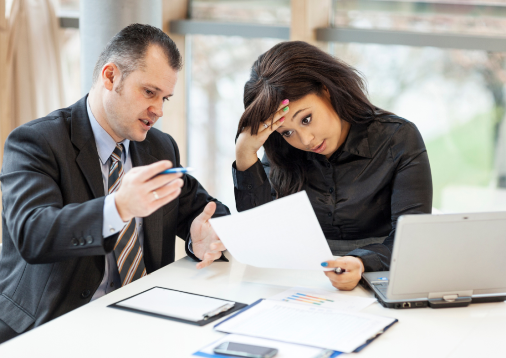 Business executives reviewing complex reports, appearing frustrated as they address common Power BI issues and discuss solutions for improved data insights.