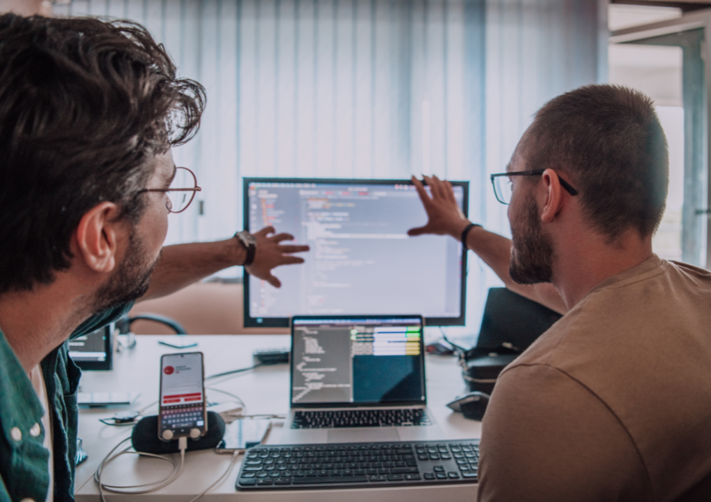Two IT professionals integrating ServiceNow with Power BI, analyzing data on multiple screens to optimize dashboard performance and reporting.